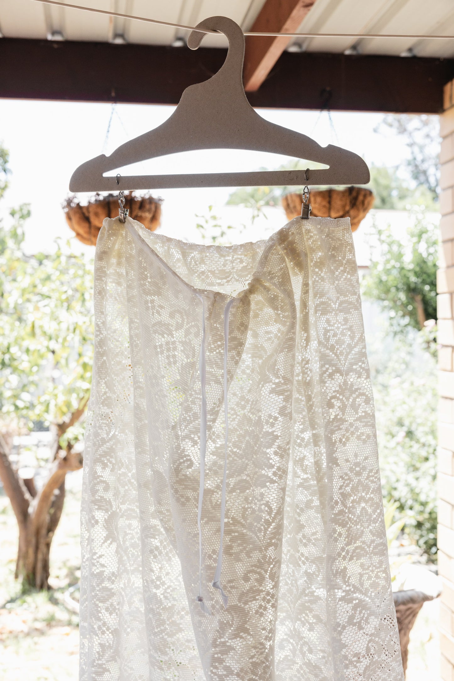 Lace garment on a hanger with a blurred outdoor background